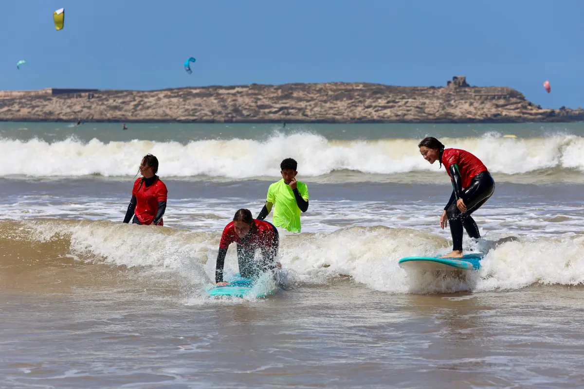 Surf lesson on Essaouira Bay — beginners riding their first whitewater waves